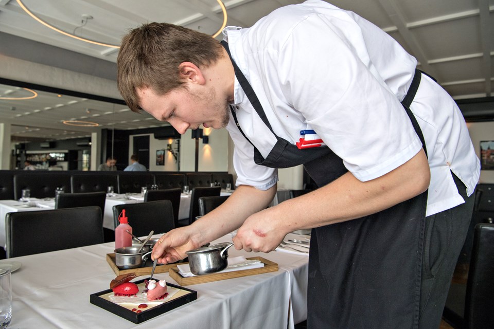 Køkkenchef Lasse Dalsager har ansvaret for alle lyksalighederne. Her er han ved at skabe et kunstværk ved bordet - gastroart hedder det - og ud over at det smagte himmelsk, var det en festlig gimmick med kunstneren så tæt på. Carl Chr. Madsen og Kurt Bering (foto)