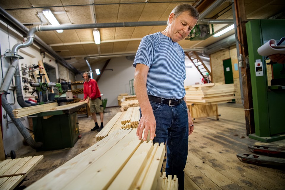 Victor Jensby Søgaard rører helt automatisk ved alle de stykker træ, han kommer forbi på rundturen gennem fabrikken. Han kom i lære som tømrer i 1965, og det er helt essentielt for ham, at døre og vinduer skal fremstilles i fuldtræ - laminat og plast er bandlyst. I baggrunden ses Jan Lauridsen, der blev ansat i firmaet for snart 40 år siden - to år efter, at virksomheden blev etableret. Foto: Diana Holm Lone Lærke Krog