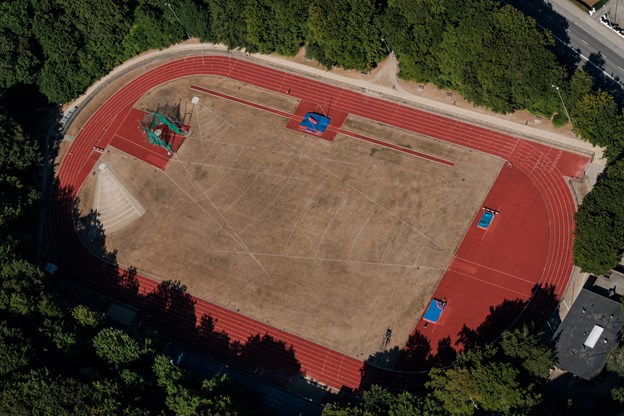 Skovdalen atletikstadion. Her klarer man sig trods det svedne græs, der dog snart får en hjælpende hånd. Anne Helene Kahr Thomsen og Lasse Sand (foto)